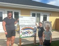 cheque presentation in front of early learning building